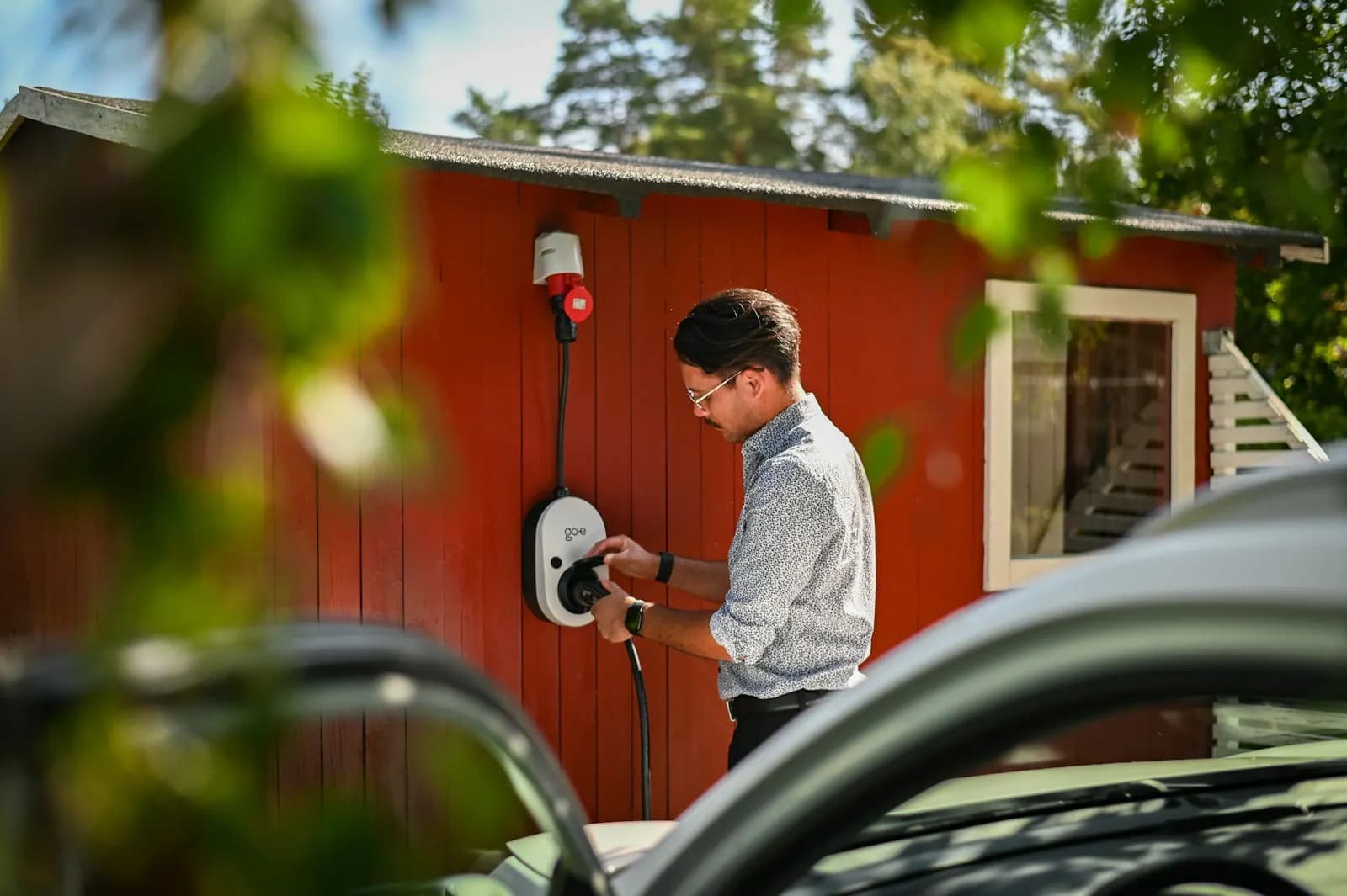 Vehicle owner connecting a modern electric vehicle to a home charger