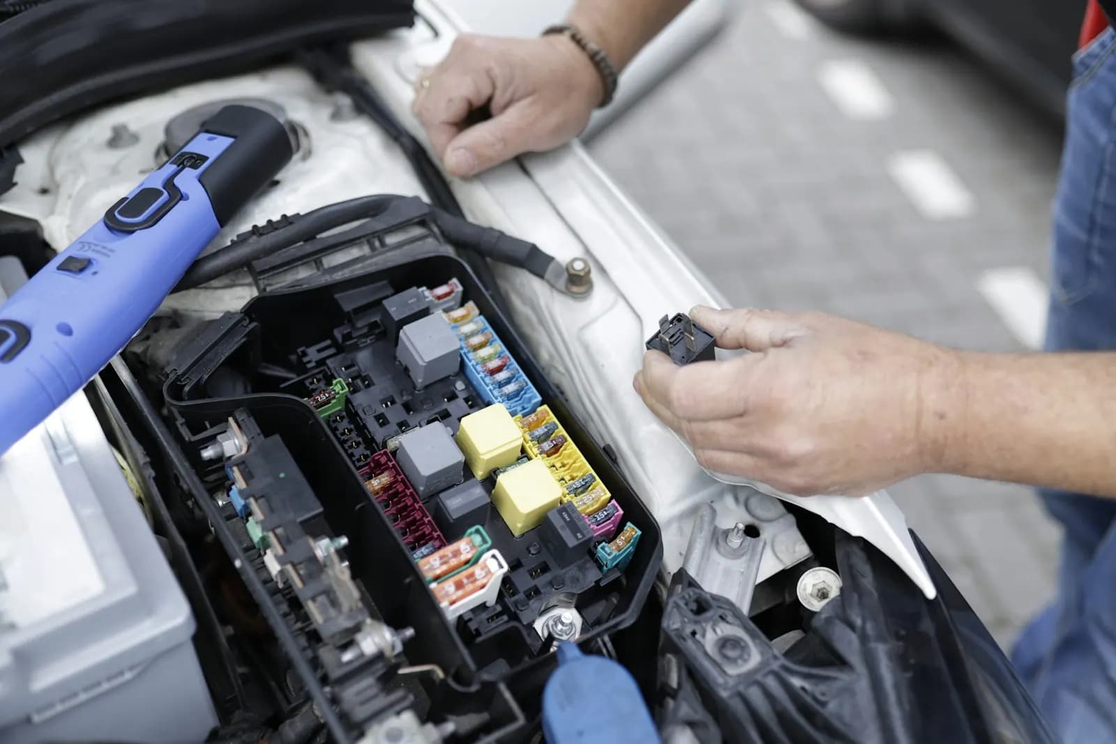Automotive technician inspecting a vehicle electrical system